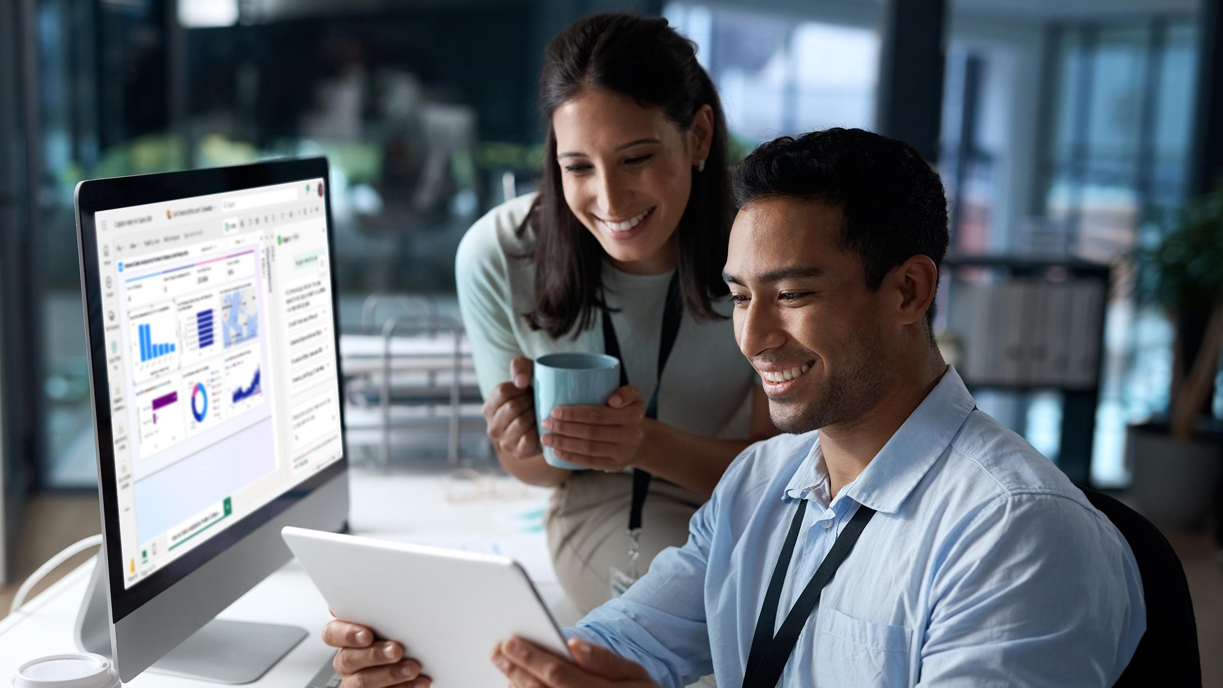 Two women working with Microsoft CoPilot on a large screen office computer