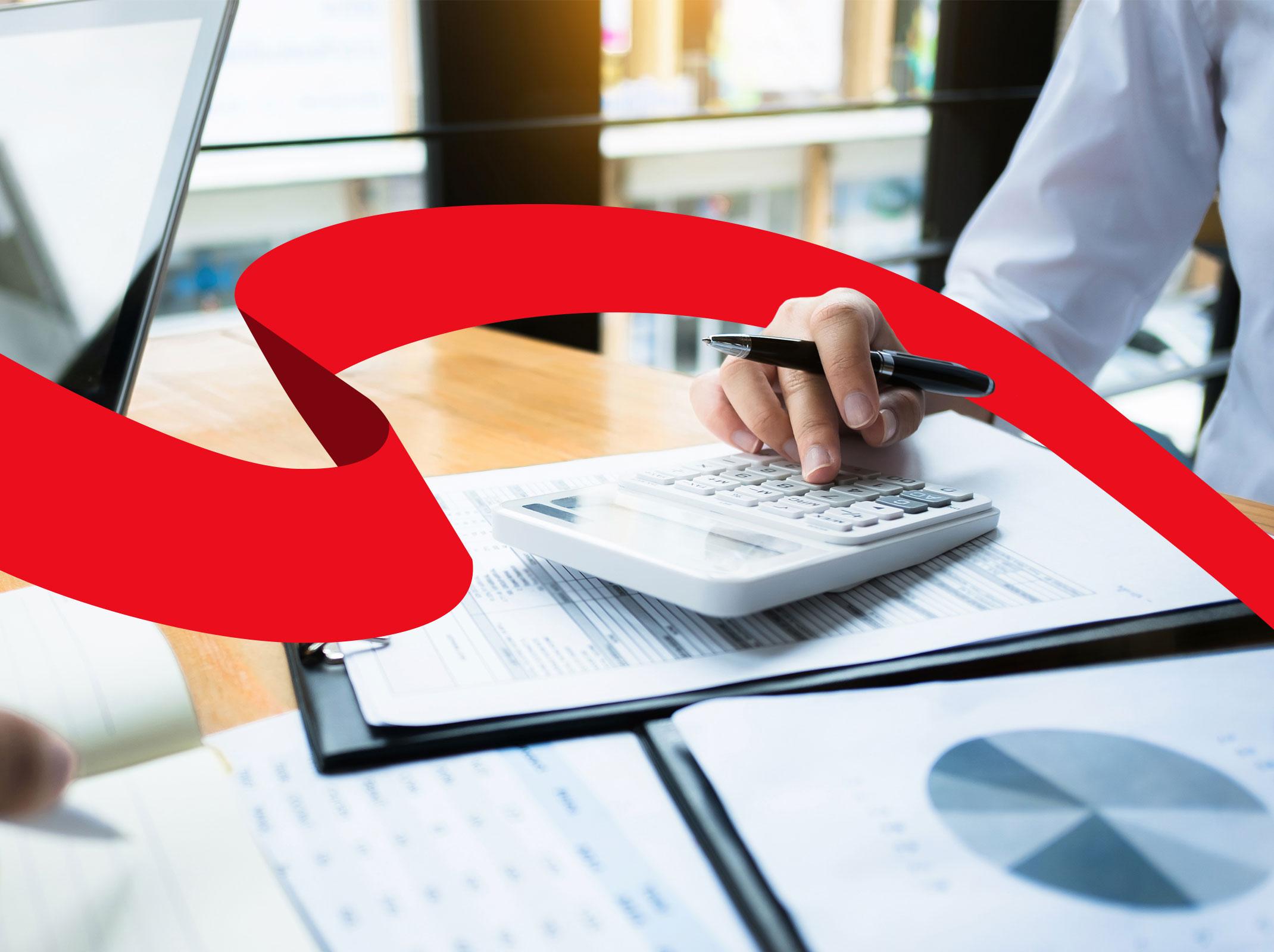 Accounting professional using a calculator and computer in an office setting