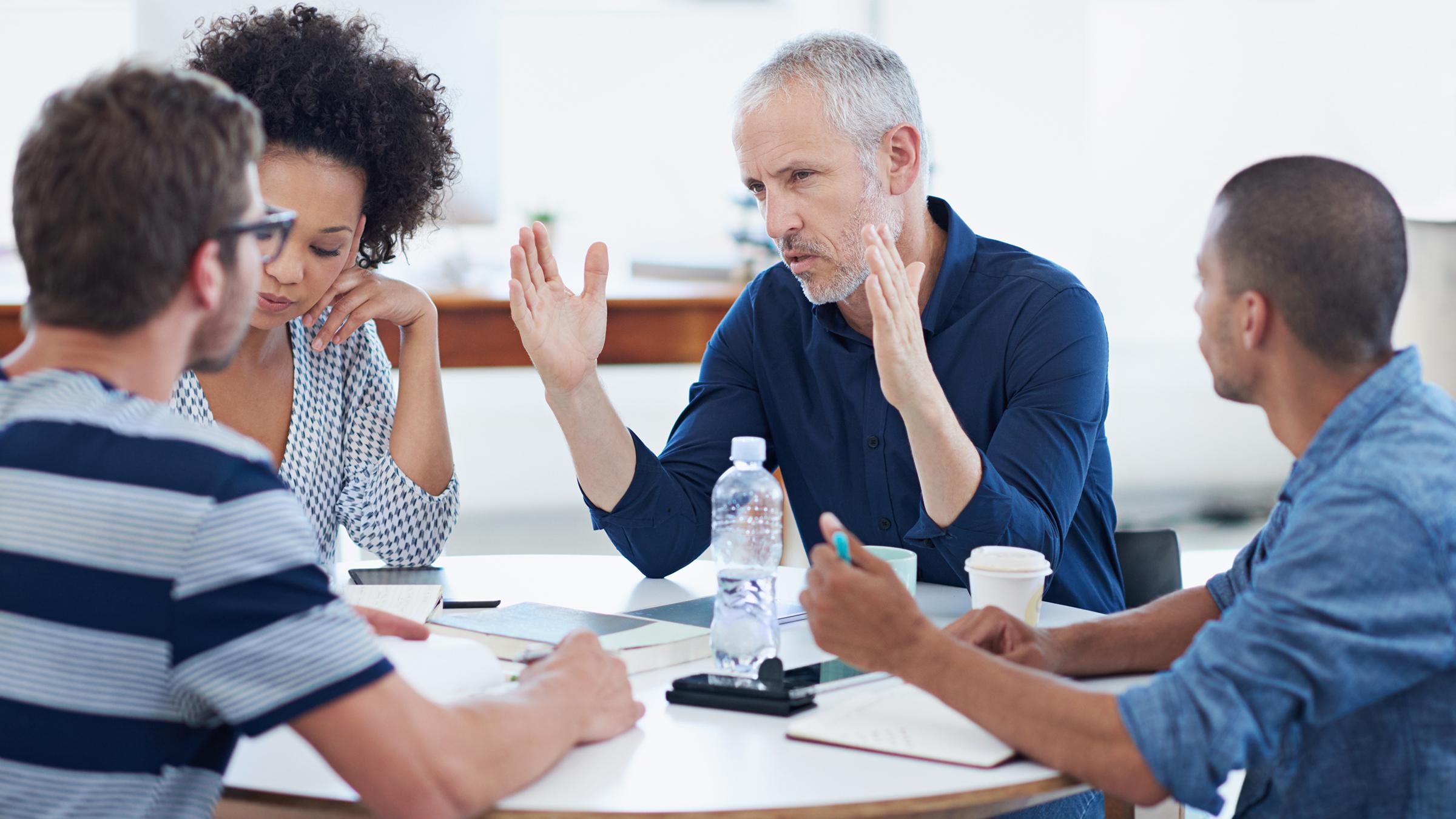 Businesspeople gathered in serious discussion at table