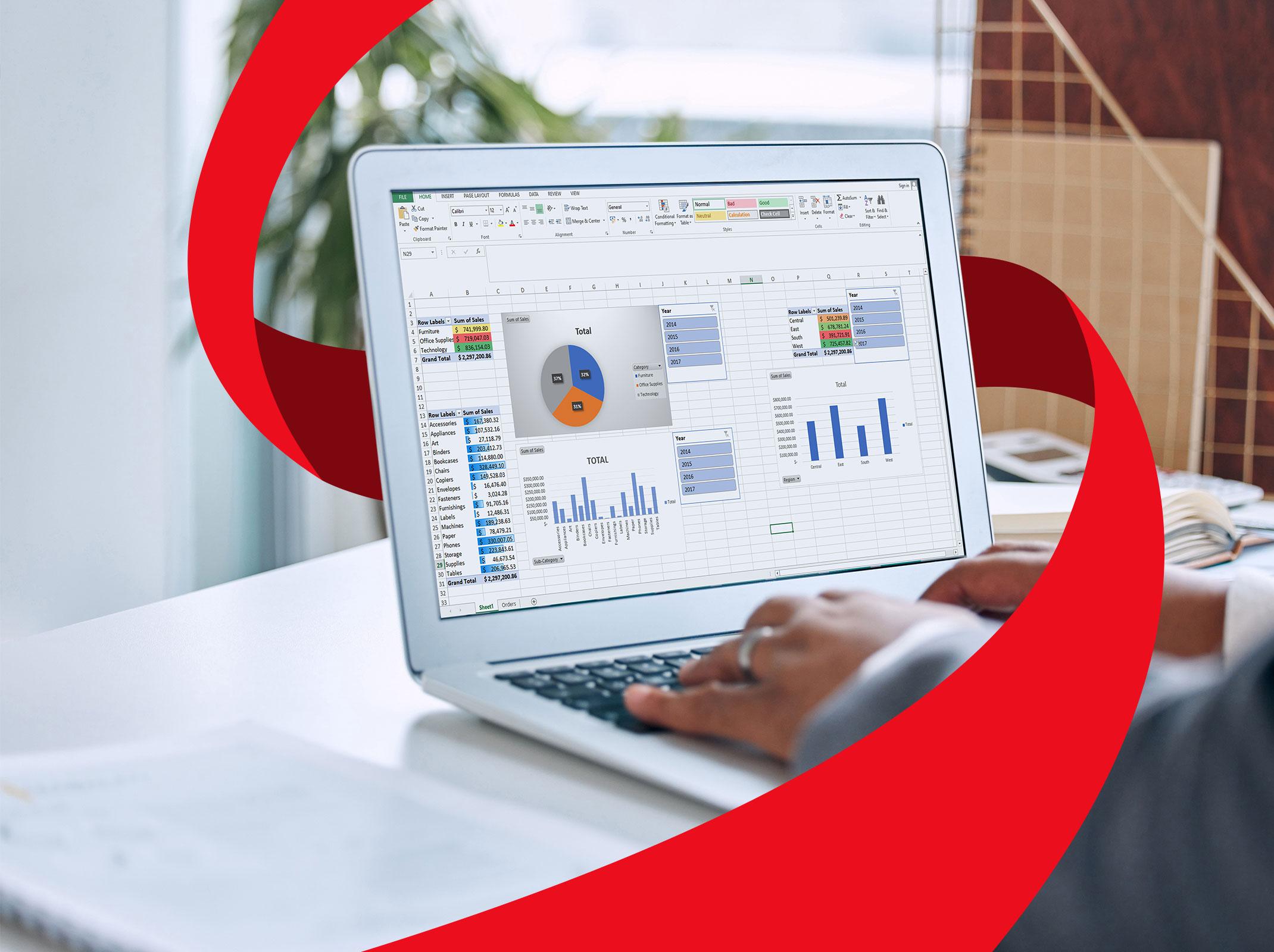 A business person working on a laptop. On the laptop are Microsoft Excel graphs, charts and PivotTables.