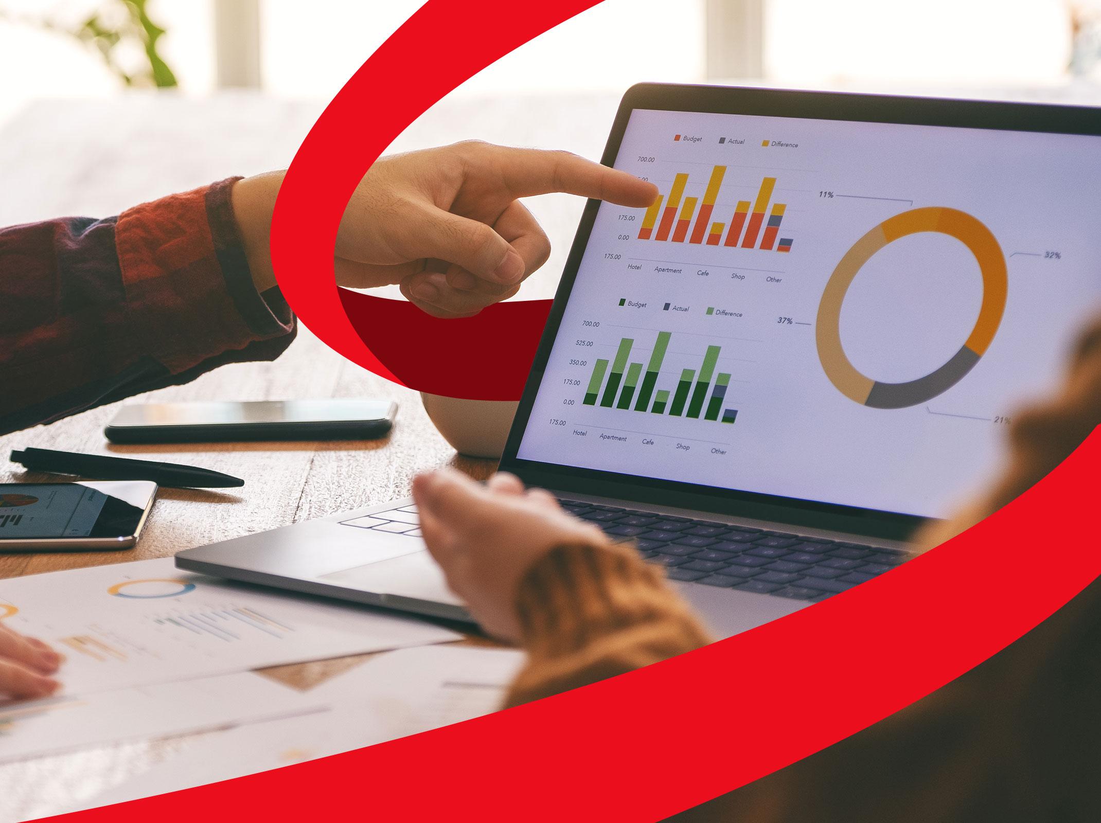 Business professionals reviewing charts and graphs created in Power BI on a laptop in a business setting.